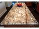 Close-up of a kitchen island with granite countertop and bowl of apples at 8035 Magnolia Way, Roswell, GA 30075