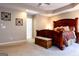 Bedroom features a large wooden bed, tray ceiling, and neutral carpet at 8035 Magnolia Way, Roswell, GA 30075