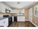 Compact kitchen featuring modern appliances, granite countertops, and white cabinetry at 1854 Shadydale Se Ave, Atlanta, GA 30315