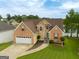 A beautiful brick and siding home with a two-car garage, spacious driveway and lush green lawn at 105 Providence Ct, Carrollton, GA 30116