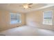 Spacious bedroom with neutral walls, patterned carpet, and a ceiling fan at 105 Providence Ct, Carrollton, GA 30116