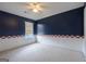 Bedroom with accent wall features neutral carpet, ceiling fan, and natural light at 105 Providence Ct, Carrollton, GA 30116
