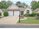 Charming home featuring a two-car garage, manicured lawn, and welcoming stone and stucco facade at 323 Newfield Way, Peachtree City, GA 30269