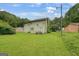 Spacious backyard showing the house and lush greenery, with some lawn equipment visible at 3570 Keels Ln, Atlanta, GA 30349
