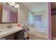 Well-lit bathroom featuring a modern vanity, mirror, soaking tub, and window at 3570 Keels Ln, Atlanta, GA 30349