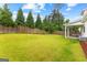 Lush green backyard with a wood fence and a covered patio, perfect for outdoor activities at 1102 Maybeck Way, Peachtree City, GA 30269