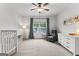 Bright bedroom with a crib, cozy chair, and large window at 1102 Maybeck Way, Peachtree City, GA 30269