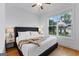 Bright bedroom with hardwood floors, a modern ceiling fan, and a view of the neighborhood at 1102 Maybeck Way, Peachtree City, GA 30269