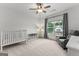 Bright bedroom with a crib, cozy chair, and large window at 1102 Maybeck Way, Peachtree City, GA 30269