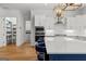Close-up showcasing the kitchen island with white countertops, storage, seating, and modern appliances and pantry in the background at 1102 Maybeck Way, Peachtree City, GA 30269