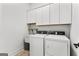 Functional laundry room featuring white washer and dryer units and ample cabinet space above at 1102 Maybeck Way, Peachtree City, GA 30269