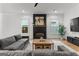 Cozy living room featuring a dark fireplace mantel, modern decor, a large sofa, and plenty of natural light from the windows at 1102 Maybeck Way, Peachtree City, GA 30269
