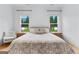 Bright main bedroom with two windows, natural light, wood floors, and minimalist furniture at 1102 Maybeck Way, Peachtree City, GA 30269