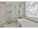 Elegant bathroom with soaking tub, glass shower, and natural light from the window at 395 W Mcintosh Rd, Brooks, GA 30205