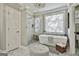 Bright bathroom featuring a freestanding tub, a separate shower, and elegant finishes at 395 W Mcintosh Rd, Brooks, GA 30205