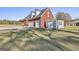 Brick home featuring attached garages, storage shed, and a well-maintained lawn at 395 W Mcintosh Rd, Brooks, GA 30205