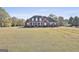 Spacious brick home with a large front lawn, covered porch, and a long driveway leading to the garages at 395 W Mcintosh Rd, Brooks, GA 30205