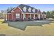 Well-maintained brick home with a welcoming front porch and lush lawn at 395 W Mcintosh Rd, Brooks, GA 30205