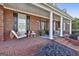 Charming brick home with a welcoming front porch featuring a swing and rocking chairs at 395 W Mcintosh Rd, Brooks, GA 30205