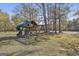 Backyard wooden playground with a slide, climbing wall, and swings for outdoor fun at 395 W Mcintosh Rd, Brooks, GA 30205