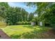 Expansive backyard with lush lawn, mature trees, and storage sheds, perfect for outdoor activities at 3778 Berdon Ln, Decatur, GA 30034