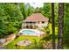 Aerial view of a backyard featuring a pool, fire pit, and wrap-around porch at 7392 N Mitchell Ct, Villa Rica, GA 30180