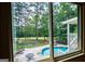 Picture window view of private in-ground pool with a patio, fence and a green backyard at 7392 N Mitchell Ct, Villa Rica, GA 30180