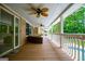 Open-air porch with ceiling fans, outdoor seating, and a view of the fenced backyard and pool at 7392 N Mitchell Ct, Villa Rica, GA 30180