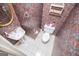 Stylish powder room with pedestal sink, tile floors, and colorful wallpaper at 7392 N Mitchell Ct, Villa Rica, GA 30180