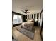 Stylish bedroom with black and white striped accent wall, fan, plush rug, and natural light from the window at 7050 Galloway Pt, Riverdale, GA 30296