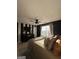 Bedroom boasts black and white striped accent wall, ceiling fan, and window letting in natural sunlight at 7050 Galloway Pt, Riverdale, GA 30296