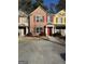 Charming brick townhome featuring red shutters, a well-maintained lawn, and a private driveway at 7050 Galloway Pt, Riverdale, GA 30296