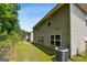 View of the side yard with green grass, trees, and the side of the home at 1875 Cutleaf Creek Rd, Grayson, GA 30017