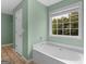 Bathroom featuring a soaking tub and a window with natural light at 230 Cobblestone Ln, Mcdonough, GA 30252