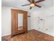 Bedroom featuring hardwood floors, ceiling fan, and a vintage wardrobe at 230 Cobblestone Ln, Mcdonough, GA 30252