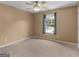 This carpeted bedroom features a ceiling fan and a window with blue curtains for a cozy space at 230 Cobblestone Ln, Mcdonough, GA 30252