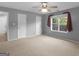 Spacious carpeted bedroom with dual closets, ceiling fan, and a window offering natural light at 230 Cobblestone Ln, Mcdonough, GA 30252