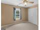 This bedroom features a ceiling fan, window with curtains, and neutral carpet at 230 Cobblestone Ln, Mcdonough, GA 30252
