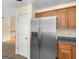 Kitchen featuring stainless steel refrigerator, light cabinets and view to the staircase at 230 Cobblestone Ln, Mcdonough, GA 30252