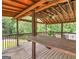 Large wooden porch featuring outdoor table and a ceiling fan at 230 Cobblestone Ln, Mcdonough, GA 30252