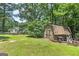 Spacious backyard featuring a storage shed, lush greenery, and access to the main house at 100 Riveredge Dr, Mcdonough, GA 30252