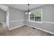 Charming dining area with wood-look flooring and a chandelier, bathed in natural light from a large window at 100 Riveredge Dr, Mcdonough, GA 30252