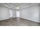 Spacious main bedroom with tray ceiling and fan, featuring wood-look floors and multiple doorways at 100 Riveredge Dr, Mcdonough, GA 30252