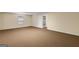 Large basement area with neutral carpet and ample space for storage at 225 Chinns Way, Hampton, GA 30228