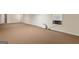 View of the spacious basement with neutral colored carpet, white walls, and a window unit air conditioner at 225 Chinns Way, Hampton, GA 30228