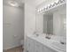 Bright bathroom with double sink vanity, large mirror, and modern lighting fixtures at 225 Chinns Way, Hampton, GA 30228