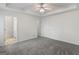 Spacious bedroom features neutral walls, plush carpet, tray ceiling with fan, and an ensuite bathroom at 225 Chinns Way, Hampton, GA 30228
