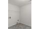 Simple laundry room with tile flooring, white walls and wire shelf at 225 Chinns Way, Hampton, GA 30228