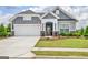Charming gray two-story home with landscaped yard and covered entryway and well manicured lawn at 411 Southbridge Pass, Peachtree City, GA 30269
