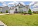 Charming gray home featuring a well-manicured lawn, landscaping, and a two car garage at 411 Southbridge Pass, Peachtree City, GA 30269